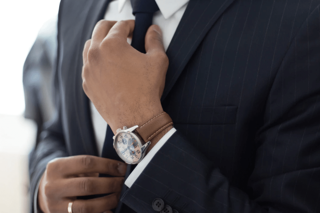 Person wearing suit adjusting tie