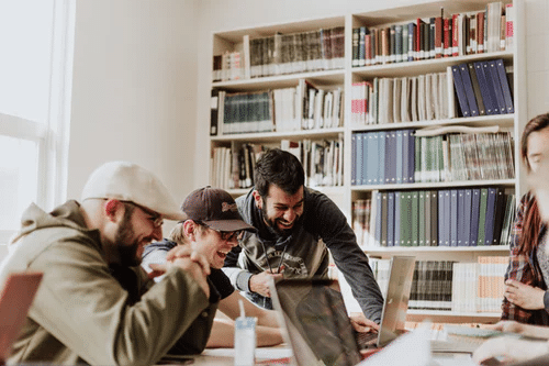 Startup employees laughing while working on laptop