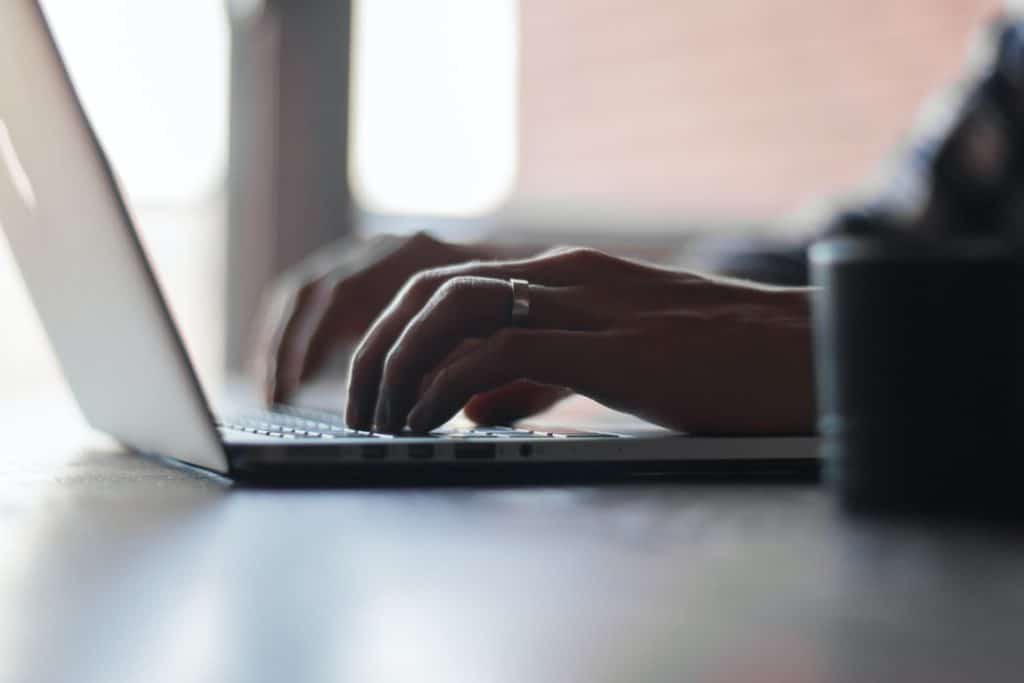 An entrepreneur reading about crowdfunding vs. crowdsourcing on their laptop.  