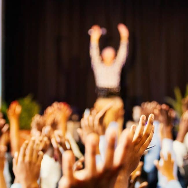 A cheering group of founders learning the difference between crowdfunding vs. crowdsourcing