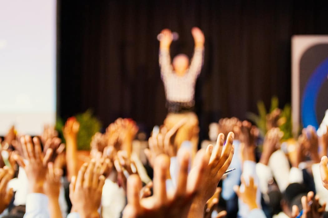 A cheering group of founders learning the difference between crowdfunding vs. crowdsourcing